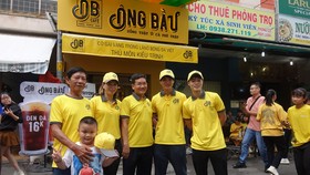 Ông Trần Thanh Hải, Chủ tịch Công ty NutiFood, cùng hai cầu thủ Văn Toàn, Tuấn Anh chụp ảnh lưu niệm cùng cô chủ Kiều Trinh. Ảnh: Anh Trần