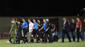 Lực lượng làm nhiệm vụ bảo vệ trận đấu trên sân Thanh Hóa đảm bảo an toàn khi đưa trọng tài rời sân. Ảnh: MINH HOÀNG
