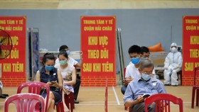 Người dân ngồi đợi ở một điểm tiêm vaccine tại TP Đà Nẵng