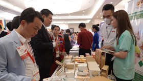 Các đại biểu tham quan một gian hàng làm sản phẩm bằng giấy, bảo vệ môi trường