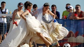 Tuy có phần vướng víu nhưng những chiếc váy cưới trắng chính là điểm nhấn khiến các cô gái thêm nổi bật tại khu vực Fan Fest. Ảnh: Reuters