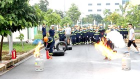 Các “lính cứu hỏa nhí” sử dụng bình chữa cháy dập tắt ngọn lửa phát ra từ bình gas