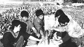 Các chiến sĩ viếng mộ đồng đội hy sinh ngày 14-3-1988 được an táng  trên đảo Sinh Tồn.  Ảnh Tư liệu