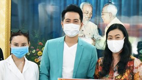 Đại diện UBMTTQ VN tại TPHCM nhận bảng tượng trưng ủng hộ của ca sĩ Nguyễn Phi Hùng và Vy Oanh