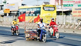 Người dân sử dụng xe máy hút đinh trên quốc lộ 1A đoạn qua huyện Bình Chánh, TPHCM. Ảnh: CAO THĂNG