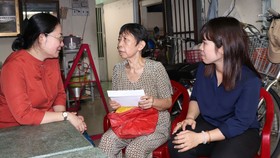 Đảng viên trên địa bàn quận 8 thăm hỏi và trao hỗ trợ cho bà Cổ Thị Thâm (giữa)  thời điểm tháng 6-2020. Ảnh: THÁI PHƯƠNG