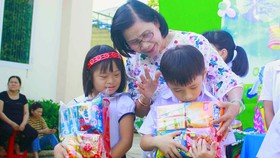 Cô Nguyễn Thị Thu Hà, Giám đốc Trung tâm Nuôi dạy trẻ khuyết tật Võ Hồng Sơn, trao quà cho trẻ khuyết tật