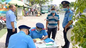 Thanh tra GTVT lập biên bản vi phạm quy định về đảm bảo trật tự an toàn giao thông trên đường Kinh Dương Vương, quận Bình Tân. Ảnh: CAO THĂNG