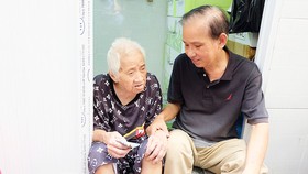 Ông Trần Văn Thanh thăm hỏi bà Trần Thị Bạch Yến, người mới được ông giúp sửa chữa nhà