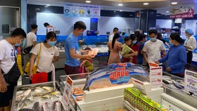 Người tiêu dùng mua thủy sản khuyến mãi tại một siêu thị ở TPHCM. Ảnh: CAO THĂNG