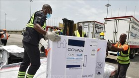 Nhân viên bốc dỡ các thùng vaccine ngừa COVID-19 được viện trợ theo chương trình COVAX toàn cầu, tại Abidjan, Bờ Biển Ngà, ngày 26-2-2021. Ảnh: AFP/TTXVN