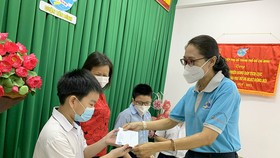 Hội Liên hiệp Phụ nữ TPHCM trao bảo trợ học tập cho trẻ. Ảnh: HỒNG HẢI