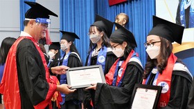 GS-TS Nguyễn Minh Hà, Hiệu trưởng Trường ĐH Mở, trao bằng tốt nghiệp cho các tân cử nhân ngày 13-3