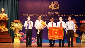 Bí thư Thành ủy TPHCM Nguyễn Văn Nên, Chủ tịch UBND TPHCM  Phan Văn Mãi trao cờ truyền thống của UBND TPHCM cho Sở Tư pháp. Ảnh: MAI HOA
