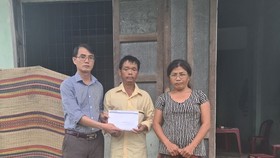 Đại diện Báo SGGP tại miền Trung trao tặng tiền bạn đọc hỗ trợ vợ chồng anh Phùng Ngọc Sơn. Ảnh: NGUYỄN CƯỜNG 
