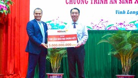 Ông Nguyễn Đăng Thanh – Phó Tổng Giám đốc HDBank (trái) trao tặng kinh phí xây dựng 100 căn nhà đại đoàn kết, ông Lữ Quang Ngời - Chủ tịch UBND tỉnh Vĩnh Long đại diện nhận