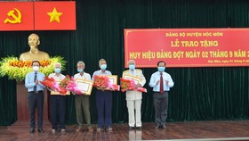 Đồng chí Trần Lưu Quang (bìa trái) tặng hoa chúc mừng các đảng viên 60 năm, 55 tuổi Đảng