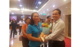 Đồng chí Trần Lưu Quang tặng hoa chúc mừng đoàn đại biểu già làng, trưởng bản tiêu biểu tỉnh Cao Bằng đến TPHCM