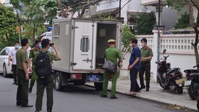 Lực lượng công an đưa ông Phạm Văn Điểu (áo xanh) lên xe chuyên dụng sau khi đọc lệnh bắt, khám xét nhà riêng. Ảnh: NGUYỄN CƯỜNG