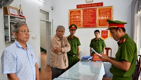 Phòng Cảnh sát kinh tế tống đạt các quyết định khởi tố và Lệnh bắt bị can để tạm giam đối với Thái Minh Hoàng (bên trái) và Nguyễn Đình Tấn (ở giữa). Ảnh: CACC