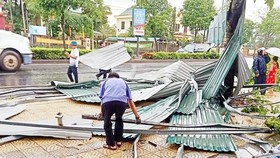 Lốc xoáy đánh bay mái nhà ở thị trấn Phong Điền ra QL 1A.