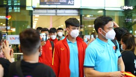 Các thành viên của đội tuyển Việt Nam di chuyển ra ga quốc tế ở cảng hàng không Tân Sơn Nhất. Ảnh: HỮU THÀNH