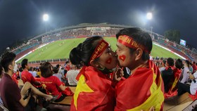Cặp đôi yêu bóng đá Việt Nam trao nhau nụ hôn trên sân Phú Thọ. ẢNH: DŨNG PHƯƠNG