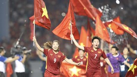 Huỳnh Như và Tuyết Dung cầm cờ tổ quốc ăn mừng chiến thắng. ẢNH: DŨNG PHƯƠNG