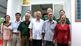 Các đại biểu chụp hình lưu niệm bên Nhà đồng đội vừa cất cho đồng chí Thượng tá Nguyễn Chiến Lang