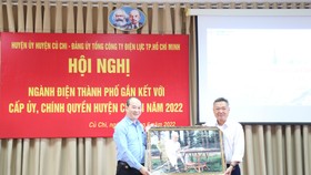 Đồng chí Phạm Quốc Bảo (phải) tặng quà lưu niệm  cho lãnh đạo huyện Củ Chi tại hội nghị ngành điện TPHCM gắn kết với cấp ủy, chính quyền địa phương