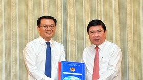 Chủ tịch UBND TPHCM Nguyễn Thành Phong trao quyết định cho đồng chí Lâm Đình Thắng. Ảnh: VIỆT DŨNG