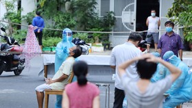 Nhân viên y tế lấy mẫu xét nghiệm cộng đồng người dân trong khu vực “vùng xanh” phường Phước Long, TP Nha Trang. Ảnh: QUỲNH ANH