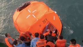 Lực lượng chức năng đưa các thuyền viên từ phao cứu sinh lên tàu