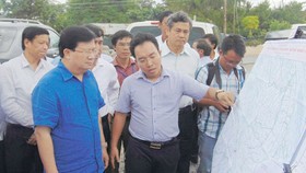 Phó Thủ tướng Trịnh Đình Dũng nghe báo cáo về dự án xây dựng cầu Đại Ngãi. Ảnh: MINH LUÂN
