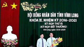 Ông Trần Văn Rón, Bí thư Tỉnh ủy Vĩnh Long (bên trái), tặng hoa chúc mừng ông Lữ Quang Ngời. Ảnh: PHAN THANH