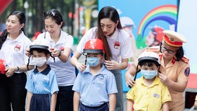 Hoa hậu Lương Thùy Linh vận động đội mũ bảo hiểm cho trẻ em