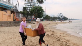 Người dân Phú Quốc tự nguyện nhặt rác tại bãi biển gần cửa sông Dương Đông. Ảnh: QUỐC BÌNH