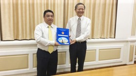 Phó Chủ tịch UBND TPHCM  Lê Văn Khoa trao quyết định cho ông Võ Khánh Hưng (phía bên trái).