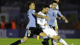 Messi trong vòng vây của hậu vệ Uruguay. Ảnh: AP
