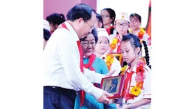 Standing Deputy Secretary of the Ho Chi Minh city Party Committee Tat Thanh Cang offered certificates of merit to outstanding children. (Photo: Sggp)