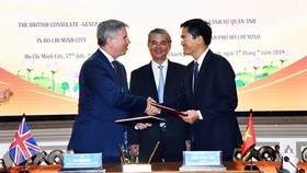 Ian Gibbons, Consul General of the UK in Ho Chi Minh City ( L) and director of the HCMC’s Department of Transport, Tran Quang Lam hands over agreements. (Photo: VNA)