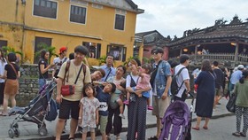 Tourists visit Hoi An ancient town.