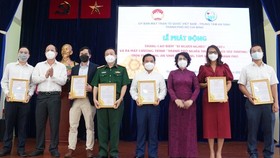 Vice Secretary of the HCMC Party Committee Nguyen Ho Hai (2nd,L) and Chairwoman of the HCMC chapter of Vietnam Fatherland Front To Thi Bich Chau (3rd, R) present letters of thank to donators. (Photo: SGGP)