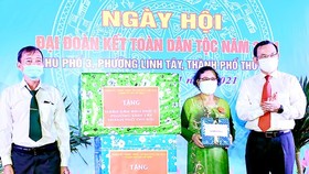 Secretary of the HCMC Party Committee Nguyen Van Nen (R) presents gifts to people in the quarter No.3 of Thu Duc City’s Linh Tay Ward. (Photo: SGGP)