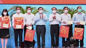 National Assembly Chairman Vuong Dinh Hue (4th, L) and Secretary of the HCMC Party Committee Nguyen Van Nen (3rd, R) present Tet gifts to the frontline forces.
