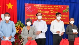 Secretary of the HCMC Party Committee Nguyen Van Nen (3rd, L), Secretary of the Party Committee cum Chairman of the People’s Council of Tay Ninh Province Nguyen Thanh Tam (2nd, R) offer Tet gifts to disadvantaged people.