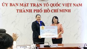 Chairwoman of the Vietnam Fatherland Front (VFF) Committee in HCM Tran Kim Yen (R) receives donation from the  HCMC Federation of Labor .