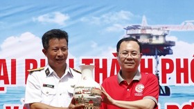 Vice Secretary of the HCMC Party Committee Nguyen Van Hieu (R) offer a gift to a representative of the Regiment 251.