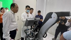 Director of the HCMC Department of Health, Dr. Tang Chi Thuong (L) at the handover of an X-ray AI device to Thanh An Commune's medical center