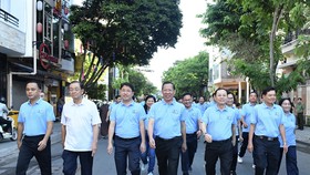 Chairman of the HCMC People’s Committee Phan Van Mai (3rd, R) and Vice Secretary of the Party Committee of the city Nguyen Van Hieu (2nd, R) participate in the walk. 